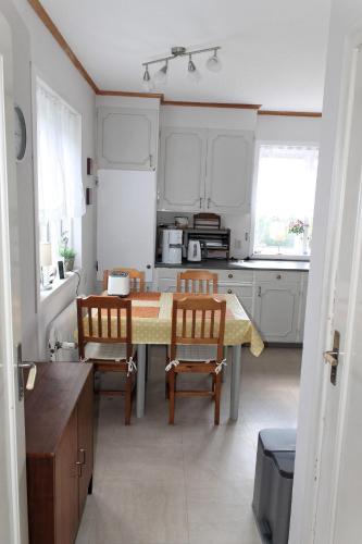 a kitchen with a table and chairs in a kitchen at Ferienhaus mit Kamin in Småland für 6 Personen in Järnforsen