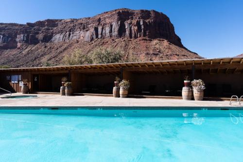 a swimming pool with a mountain in the background at Red Cliffs Lodge in Moab