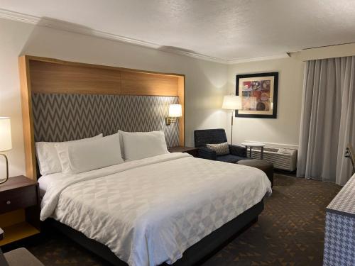 a hotel room with a large bed and a chair at Holiday Inn Rock Springs by IHG in Rock Springs