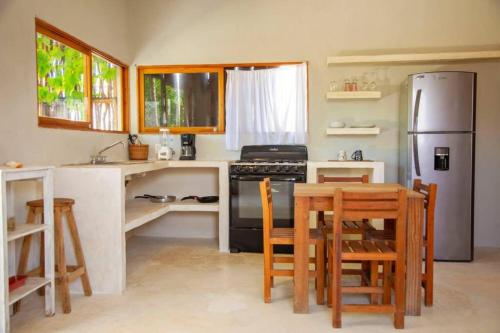 cocina con nevera, mesa y sillas en Casa Lunada, en Isla Holbox