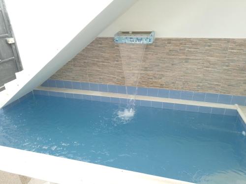 una piscina con una fuente de agua en casa turística La Alameda, en Carmen de Apicalá