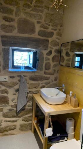a bathroom with a sink and a stone wall at El Mirador de La Duquesa in Mámoles