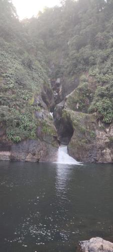 einen Fluss mit einem Wasserfall an der Seite eines Berges in der Unterkunft Nectepec in Cuetzalán del Progreso