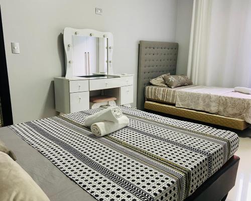 a hotel room with two beds and a mirror at Casa Privativa na Av. Garibaldi Vila A in Foz do Iguaçu