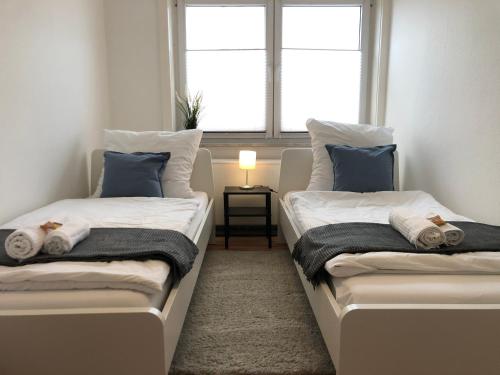 two twin beds in a room with a window at LIME HOMES: Balkon, Küche, Netflix in Barsinghausen