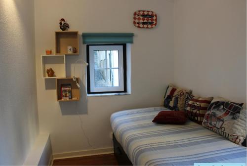 リスボンにあるCasa Da Severa Apartmentsのソファと窓付きのベッドルーム1室
