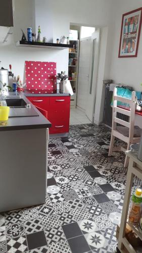 Il comprend une cuisine dotée de carrelage noir et blanc. dans l'établissement Chez audrey, à Angoulême