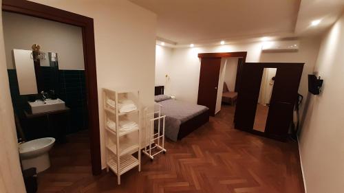 een badkamer met een bed, een wastafel en een spiegel bij Il Gran Portale in Ercolano