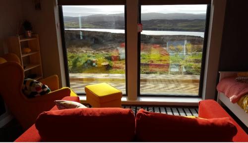 a living room with a couch and a large window at Wee Shed in Portree