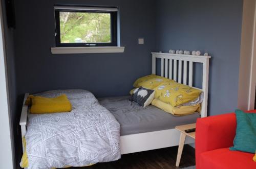 a small bedroom with a bed and a window at Wee Shed in Portree