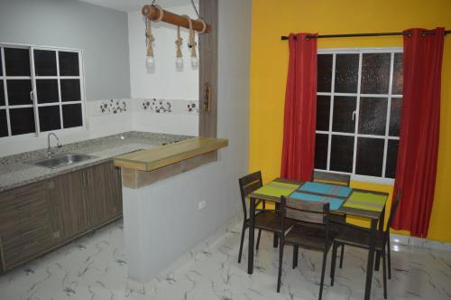 una cucina con tavolo, sedie e lavandino di Apartamento Amueblado Mi Casa Caribe, Santo Domingo a 5 minutos del Aeropuerto Internacional de las Americas a Santo Domingo