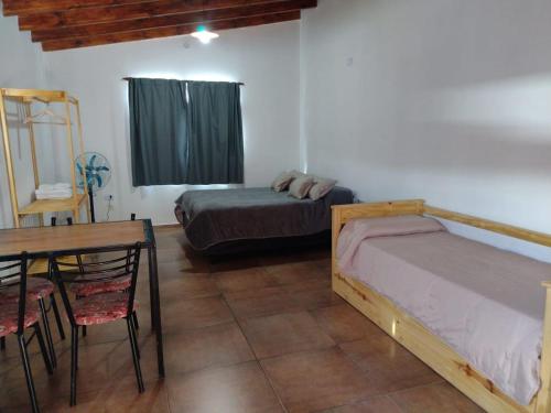 um quarto com 2 camas e uma mesa e uma mesa e cadeiras em El Sauce em Los Cocos