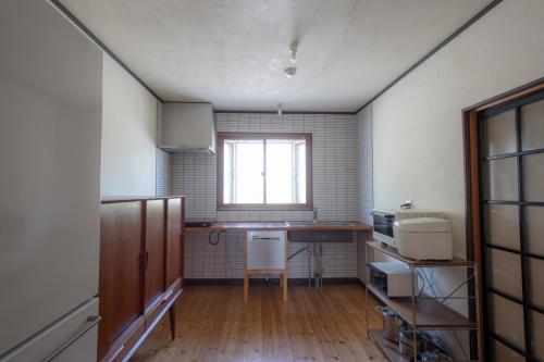 a kitchen with a table and a window in it at Nakasendo Ashida-Shuku Tateshina Akariya in Tateshina