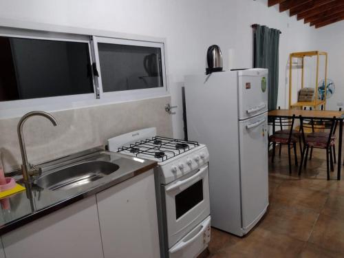 a kitchen with a sink and a stove and a refrigerator at El Sauce in Los Cocos