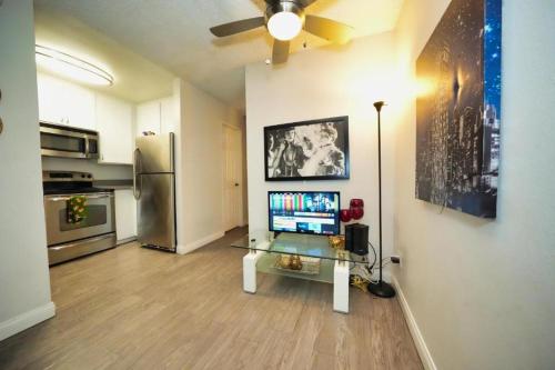 a living room with a table with a television in it at Charming Hollywood Condo with Pool & Balcony in Los Angeles