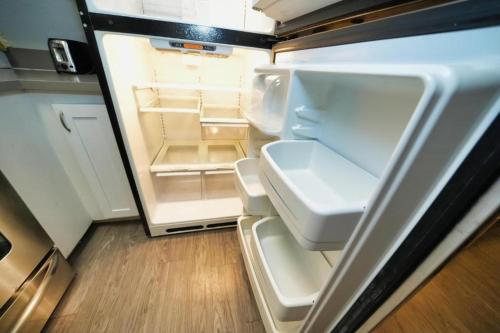 an empty refrigerator with its door open in a kitchen at Charming Hollywood Condo with Pool & Balcony in Los Angeles