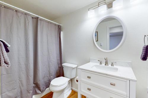 een badkamer met een toilet, een wastafel en een spiegel bij Woodbine Way Retreat in Bellingham