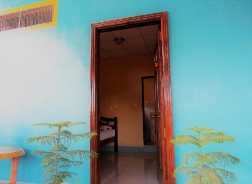 an open door to a room with a blue wall at Hospedaje Siero in Moyogalpa