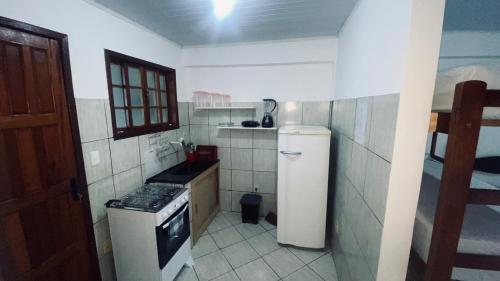 a small kitchen with a stove and a refrigerator at Quitinete standard 204 in Cabo Frio