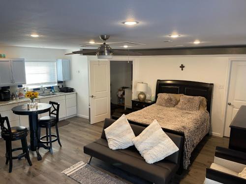 a bedroom with a bed and a table and a kitchen at Serenity home in Laplace