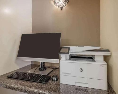 a computer monitor and a printer on a counter at Sonesta Simply Suites Plano Frisco in Plano