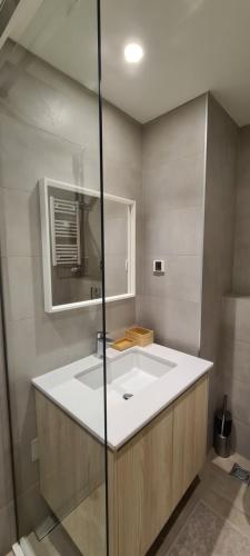 a bathroom with a white sink and a mirror at Premium Studio Apartment - Belgrade Waterfront in Sajmište