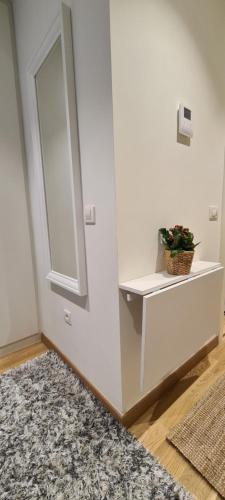 a white wall with a shelf and a mirror at Premium Studio Apartment - Belgrade Waterfront in Sajmište