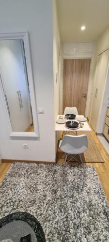 a kitchen with a table and two chairs and a rug at Premium Studio Apartment - Belgrade Waterfront in Sajmište