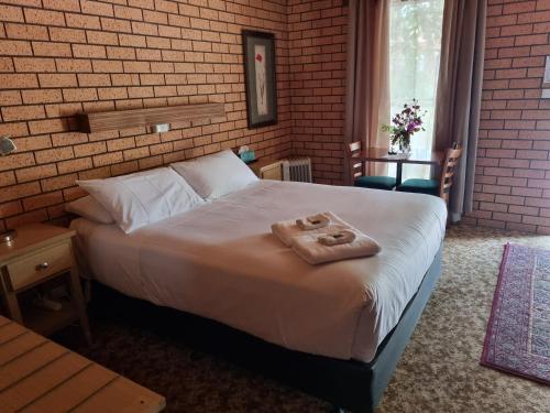 1 dormitorio con 1 cama con 2 toallas en La Cochon Rose Motel, en Saint Arnaud