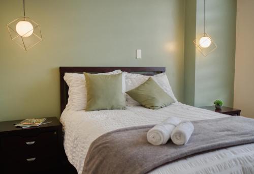 a bedroom with a bed with two towels on it at Penthouse Lujoso y moderno en el centro de Riobamba - Wanderlot Leganza in Riobamba