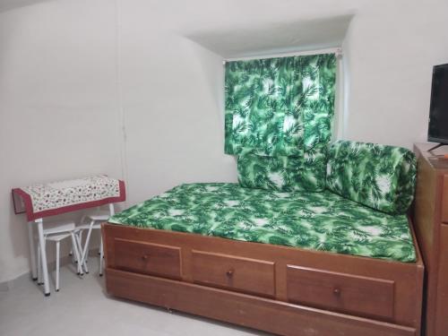 um quarto com uma cama e um sofá verde em Cabana lofft 70 em Tucuns Búzios em Búzios