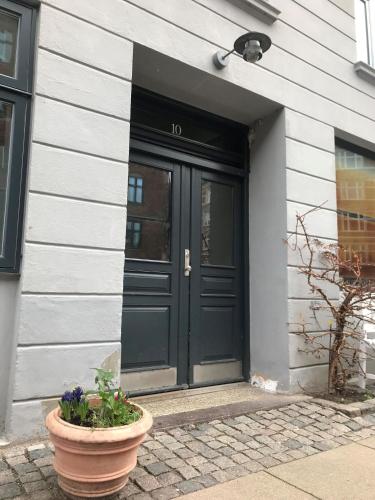 a black door on a house with a flower pot at ApartmentInCopenhagen Apartment 1159 in Copenhagen