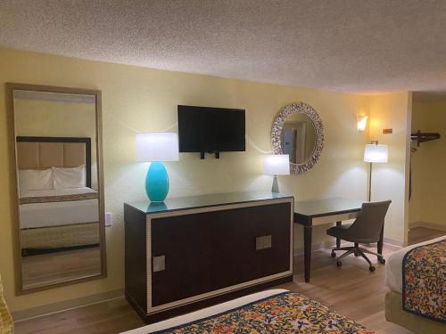 Habitación de hotel con 1 dormitorio con escritorio y espejo en OK Hotel en Oklahoma City