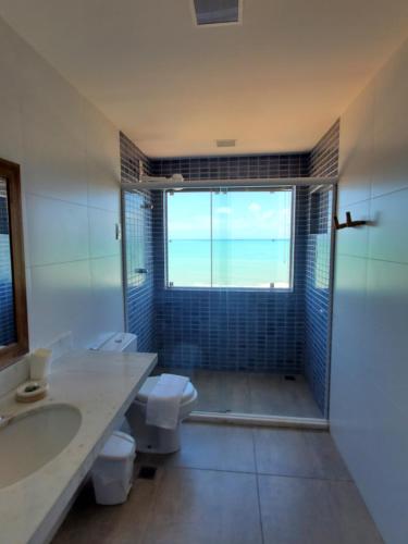 a bathroom with two toilets and a sink and a window at A CASA FORMOSA in Baía Formosa