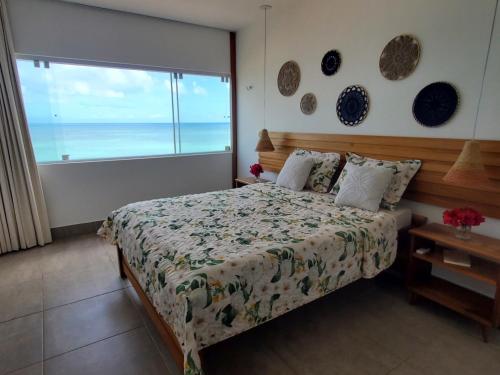 a bedroom with a bed with a view of the ocean at A CASA FORMOSA in Baía Formosa