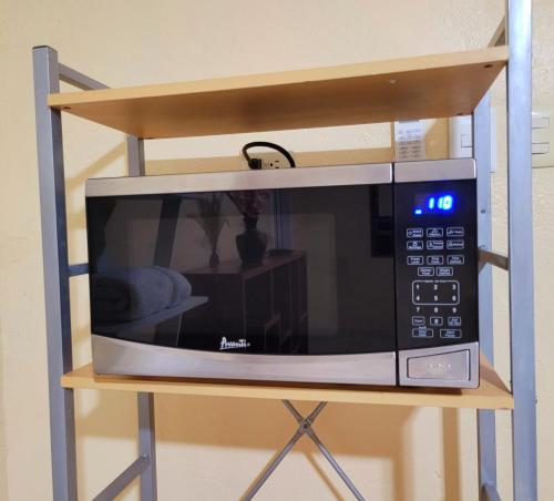 a microwave oven sitting on a shelf in a room at Alojamiento River Merendón in San Pedro Sula