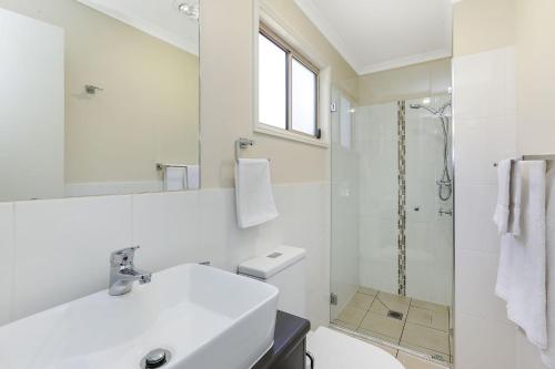 a white bathroom with a sink and a shower at Reflections Moonee Beach - Holiday Park in Moonee Beach