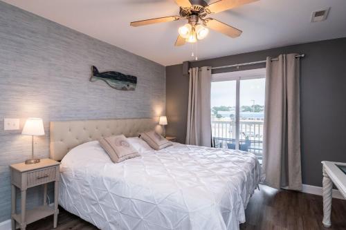 een slaapkamer met een bed en een plafondventilator bij Tres Pajaritos in Oak Island