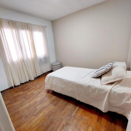 1 dormitorio con 1 cama y suelo de madera en SEMIPISO Avenida Principal centro de Mendoza en Mendoza