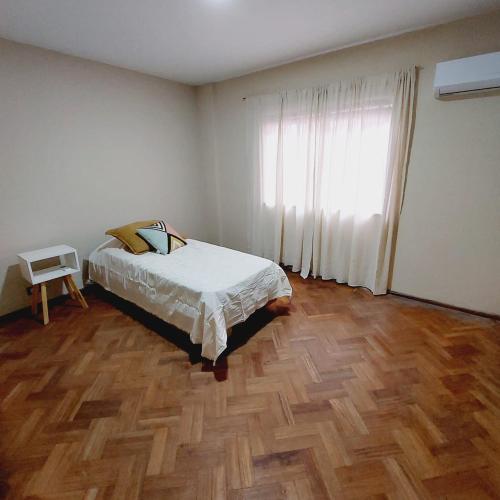 1 dormitorio con 1 cama y suelo de madera en SEMIPISO Avenida Principal centro de Mendoza en Mendoza