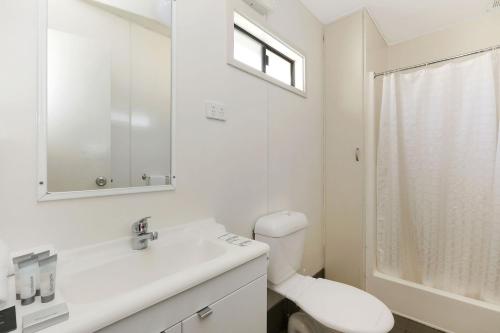 a white bathroom with a toilet and a sink at Reflections Moonee Beach - Holiday Park in Moonee Beach
