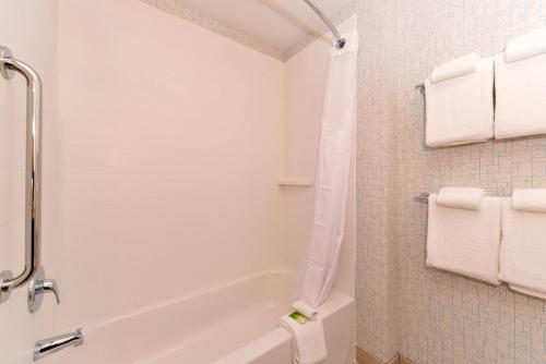 a bathroom with a tub and a toilet and towels at Holiday Inn Express & Suites Trinity by IHG in Trinity