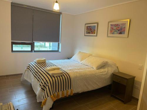 1 dormitorio con cama y ventana en Puerto Montt apartamento en playa Pelluco, en Puerto Montt