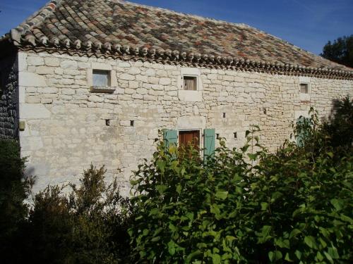 Historic holiday home with garden في Fargues: مبنى حجري قديم مع باب أخضر