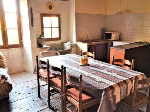 Historic holiday home with garden في Fargues: مطبخ مع طاولة وكراسي في غرفة