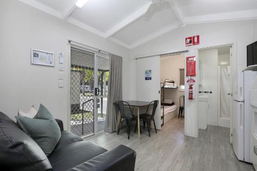 a living room with a couch and a table at Reflections Coffs Harbour - Holiday Park in Coffs Harbour