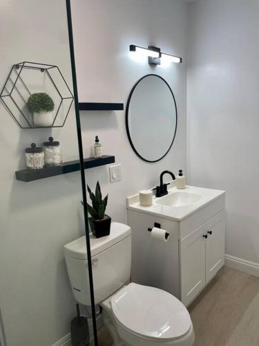 a bathroom with a toilet and a sink and a mirror at Coastal inspired apartment in downtown culver city in Los Angeles