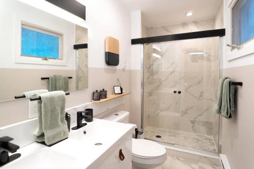uma casa de banho branca com um chuveiro e um WC. em Prattvilla -Catskill -Mountain Escape 5 BR ,3 bath with Hot tub em Prattsville