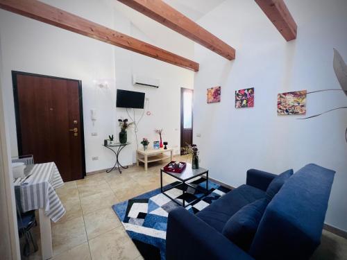 un soggiorno con divano blu e TV di West Sardinia Apartment 2 a Càbras