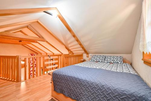 een slaapkamer met een blauw bed op een zolder bij Holiday house with a parking space Krapina, Zagorje - 20452 in Krapina